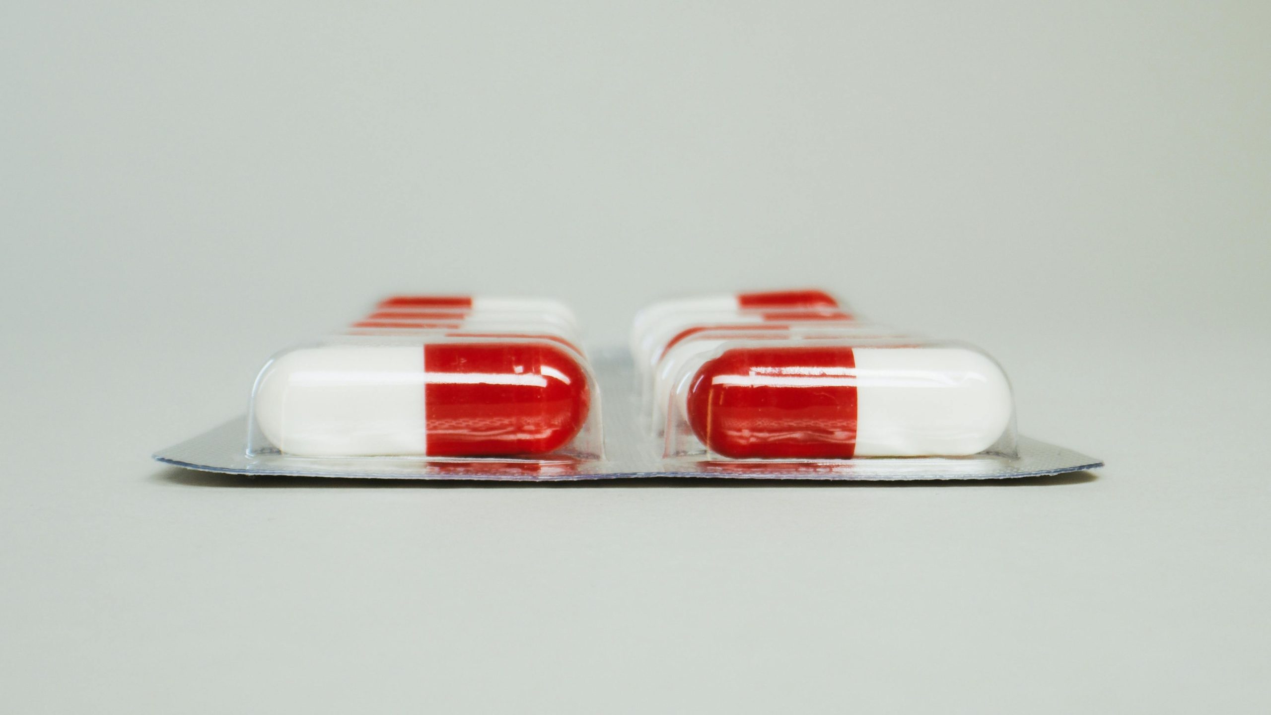Blister pack of red and white capsules isolated against a simple background.